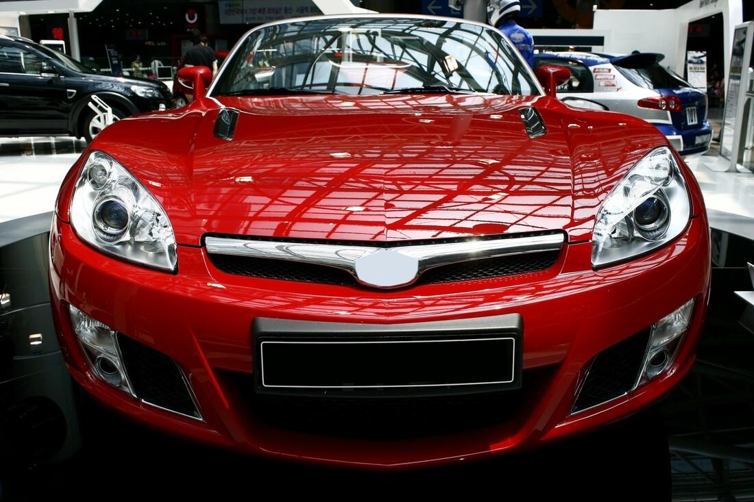 Picture of the front of a red car with tinted windows on display